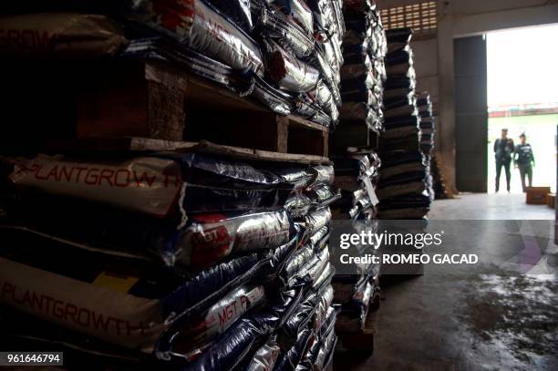 This picture taken on March 13, 2018 shows police and Ministry of Agriculture personnel inspecting alleged fake pesticides seized during a raid in a...