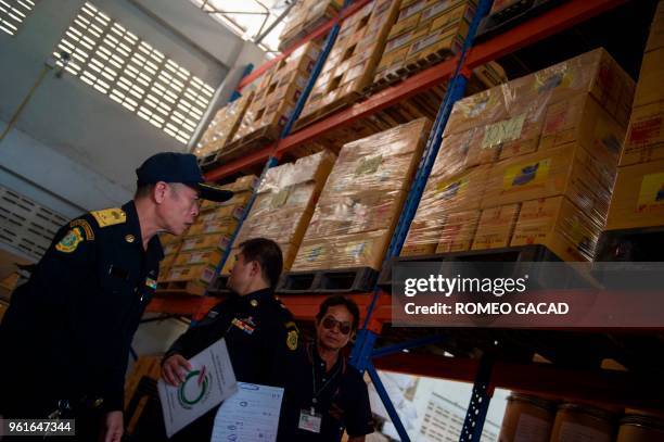 This picture taken on March 13, 2018 shows police and Ministry of Agriculture personnel raiding a warehouse looking for pesticides products in Suphan...