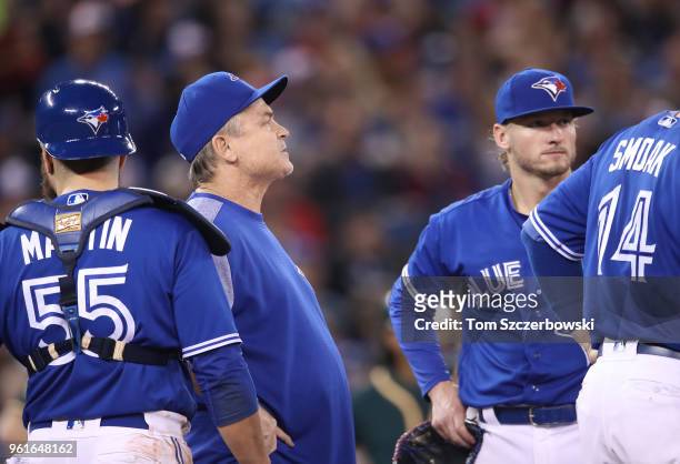 Manager John Gibbons of the Toronto Blue Jays looks on from the mound as he comes out to make a pitching change as Russell Martin and Josh Donaldson...