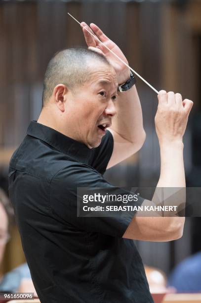 Chinese composer Tan Dun directs the Munich Philharmonic Orchestra at the Kulturpalast concert hall in Dresden, eastern Germany, during a rehearsal...