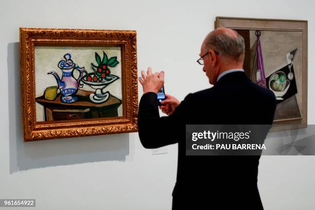 Man takes a picture of "Still Life with Cherries" by Spanish artist Pablo Picasso during the presentation of the exhibition "Picasso's Kitchen" at...