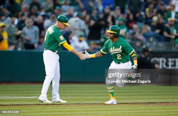 Khris Davis of the Oakland Athletics is congratulated by Third Base Coach Matt Williams while running the bases after hitting a home run during the...