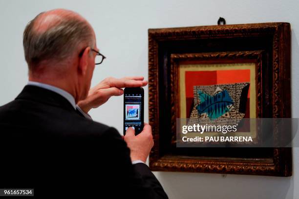 Man takes a picture of "Four Fish" by Spanish artist Pablo Picasso during the presentation of the exhibition "Picasso's Kitchen" at the Picasso...