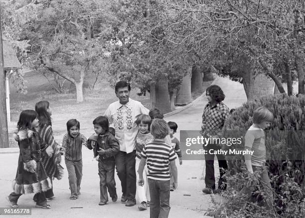 American labor leader and civil rights activist, Cesar Chavez with some of his grandchildren and children of other union staff, while taking a walk...