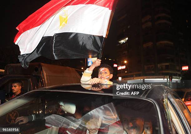 An Egyptian boy waves his national flag as he celebrates in Cairo after Egypt beat Cameroon in their African Cup of Nations quarter-final football...