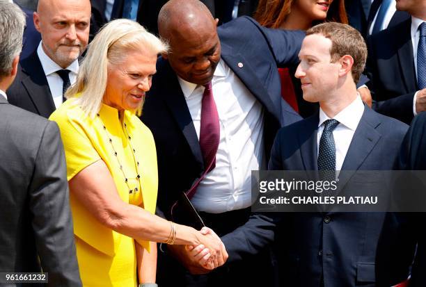 Facebook's CEO Mark Zuckerberg shakes hands with IBM's President and CEO Virginia Rometty before a family picture with guests of the "Tech for Good"...