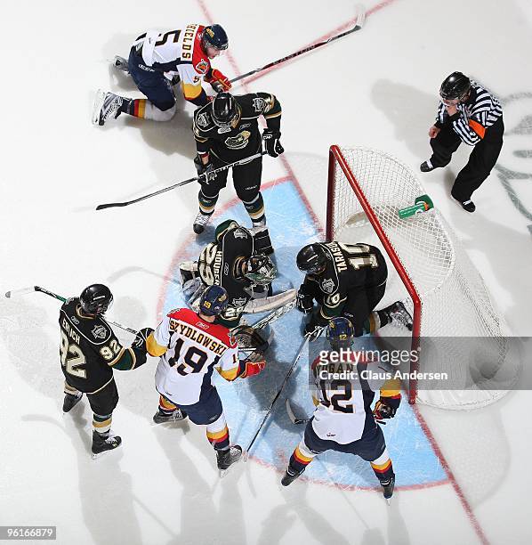 Steven Tarasuk of the London Knights gives teammate Michael Houser a hand in stopping a scoring attempt by the Erie Otters in a game on January 22,...