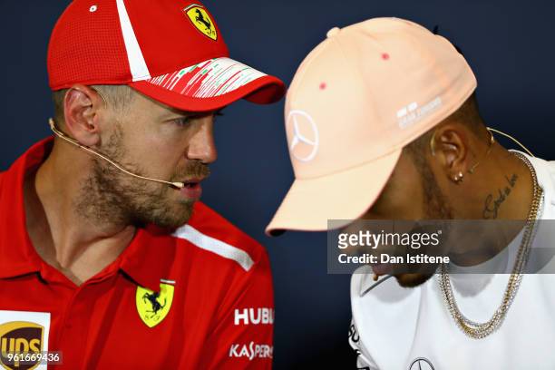 Sebastian Vettel of Germany and Ferrari talks with Lewis Hamilton of Great Britain and Mercedes GP in the Drivers Press Conference during previews...