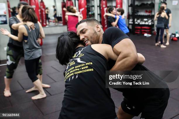 Kevin Lee grapples with a participant during an MMA masterclass at TripleFit gym on May 23, 2018 in Singapore.