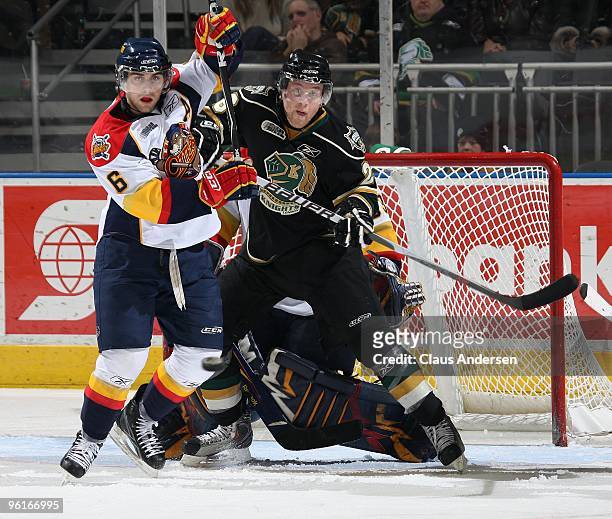 Colin Martin of the London Knights watches an incoming puck to tip as he is being tied up by Paul Cianfrini of the Erie Otters in a game on January...