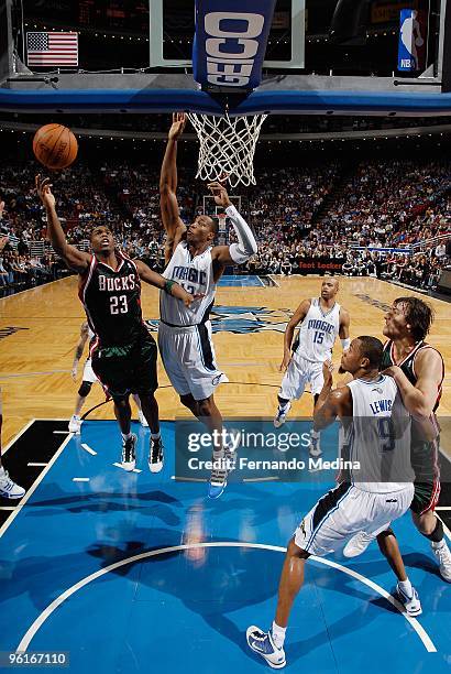 Jodie Meeks of the Milwaukee Bucks lays up a shot against Dwight Howard of the Orlando Magic during the game on December 30, 2009 at Amway Arena in...