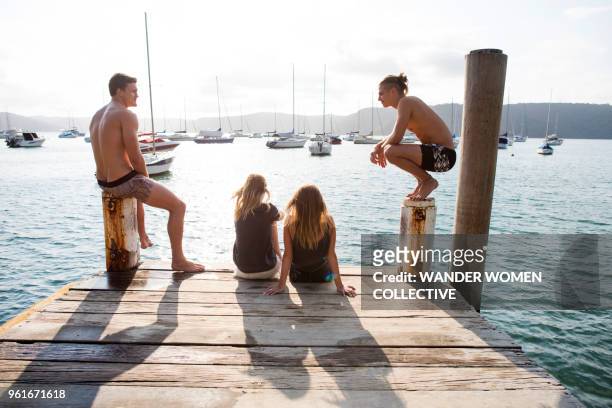group of young adults sitting at the end of a jetty - pittwater stock pictures, royalty-free photos & images