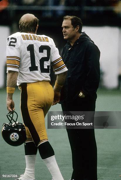 Head Coach Chuck Noll of the Pittsburgh Steelers talks with his quarterback Terry Bracshaw on the sidelines during a late circa 1970's NFL football...