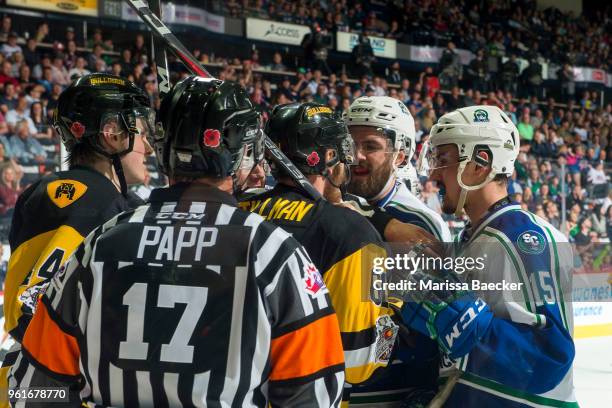 Josh Anderson and Glenn Gawdin of Swift Current Broncos get in the face of Riley Stillman of Hamilton Bulldogs during third period at the Brandt...