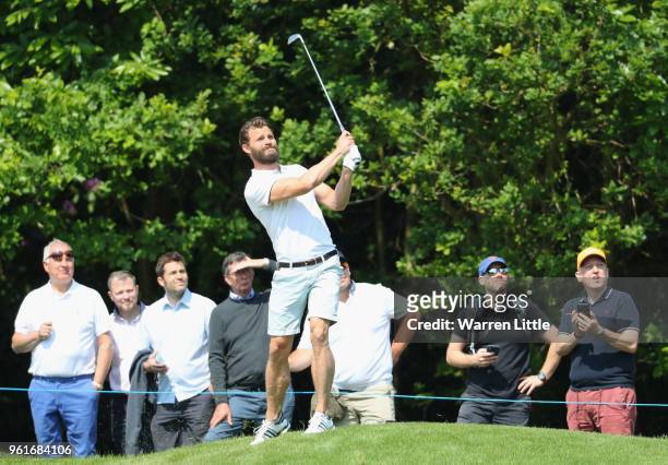 Spectators watch as actor Jamie Dornan plays a shot during the BMW PGA Championship Pro Am tournament at Wentworth on May 23, 2018 in Virginia Water,...