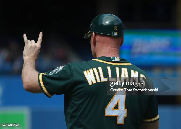 Third base coach Matt Williams of the Oakland Athletics signals to the baserunner during MLB game action against the Toronto Blue Jays at Rogers...