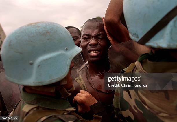 United Nations peacekeepers from Uruguay attempt to control a massive crowd of Haitians jockeying for food in front of the National Palace January...