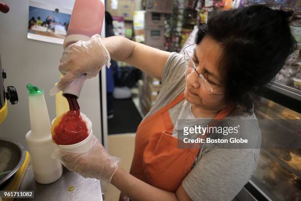 Luzmila Espinoza, owner of Frio Rico in East Boston, makes raspadilla, her version of shaved ice, on May 16, 2018. She explains that it has many...
