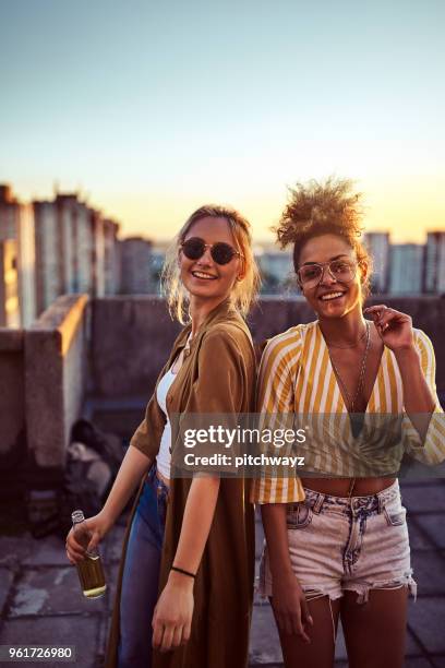 twee vrouwen die dansen op het feest. - friends sunset stockfoto's en -beelden