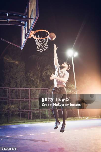de hook shot in basketbal. jonge, bebaarde mannen spelen basketbal buitenshuis - hookshot stockfoto's en -beelden