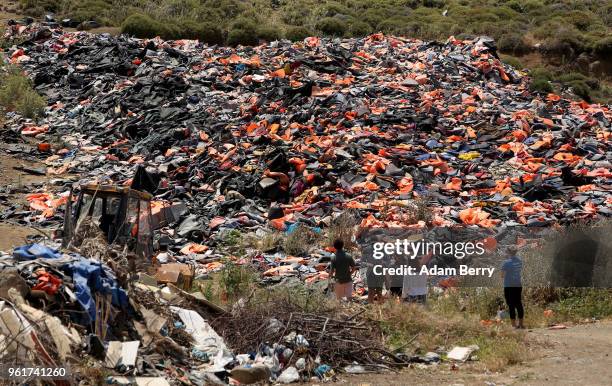 Thousands of used life preservers and pieces of rafts used by refugees in their attempted crossings from Turkey to Greece lay in a pile on the island...