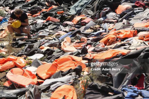 Thousands of used life preservers and pieces of rafts used by refugees in their attempted crossings from Turkey to Greece lay in a pile on the island...