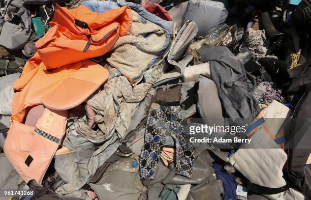 Pair of toddler's pants lays among thousands of used life preservers and pieces of rafts used by refugees in their attempted crossings from Turkey to...