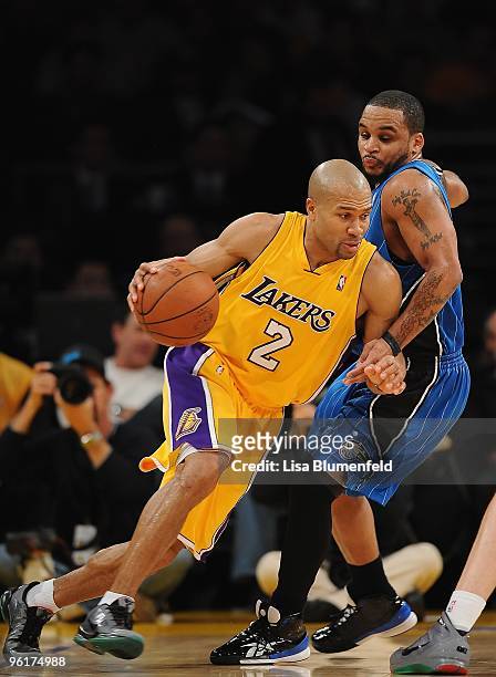 Derek Fisher of the Los Angeles Lakers drives against Jameer Nelson of the Orlando Magic at Staples Center on January 18, 2010 in Los Angeles,...