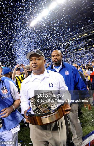 Jim Caldwell Head coach of the Indianapolis Colts walks off the field with the Lamar Hunt Trophy after defeating the New York Jets during the AFC...