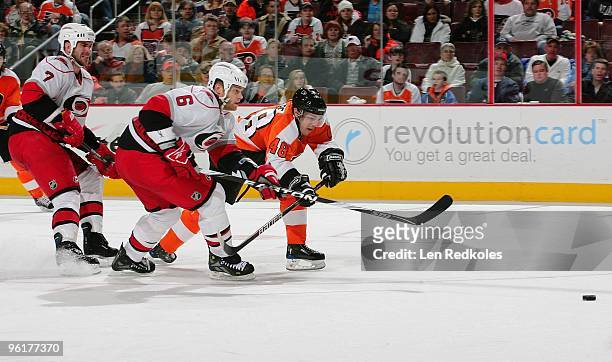 Danny Briere of the Philadelphia Flyers battles for a loose puck against Tim Gleason and Niclas Wallin of the Carolina Hurricanes on January 23, 2010...