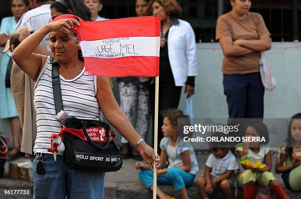 Supporter of Honduran ousted President Manuel Zelaya, holds a flag reading "Mel urges" as she waits for him to exit the Brazilian Embassy in...