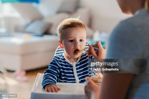 one more bite my boy! open wide! - baby food stock pictures, royalty-free photos & images