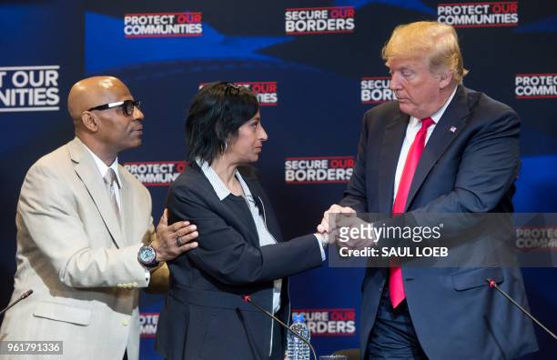 President Donald Trump embraces Evelyn Rodriguez , whose daughter was killed by MS-13 gang members, alongside her husband Freddy Cuevas, during a...