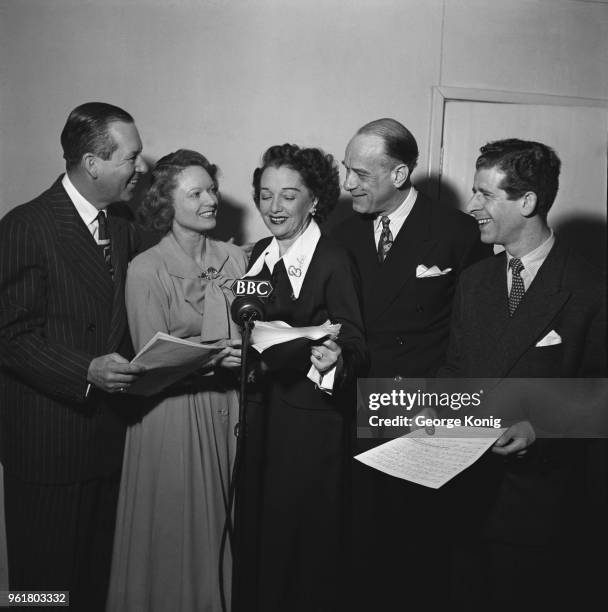 English actress Anna Neagle guest stars on a new series of the BBC comedy radio show 'Hi Gang!', February 1949. From left to right, Ben Lyon, Neagle,...