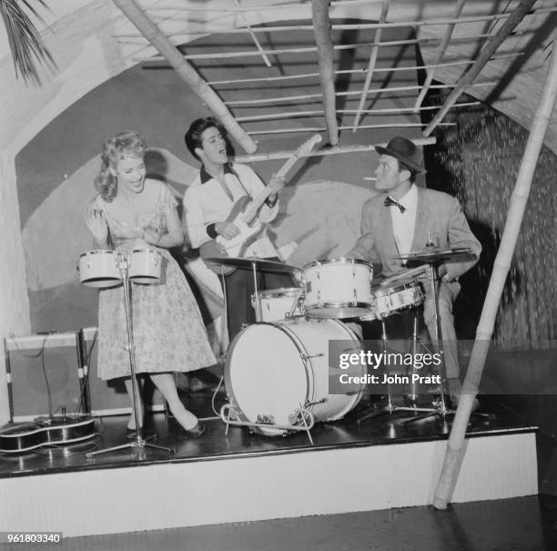 From left to right, actress Sylvia Syms, singer Cliff Richard and actor Laurence Harvey filming 'Expresso Bongo' at Shepperton Studios, UK, August...