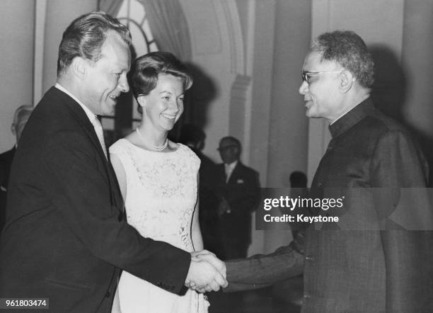 Willy Brandt , the Mayor of West Berlin, and his wife Rut, greet Indian leader Jayaprakash Narayan at a party in the Orangerie of the Schloss...
