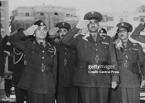 King Hussein of Jordan and Egyptian Prime Minister Gamal Abdel Nasser salute the guard of honour upon Hussein's arrival in Cairo for a six-day...