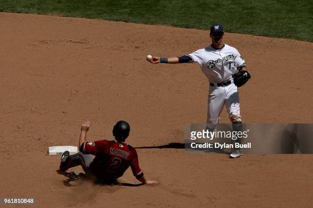 Tyler Saladino of the Milwaukee Brewers attempts to turn a double play past Jeff Mathis of the Arizona Diamondbacks in the fifth inning at Miller...