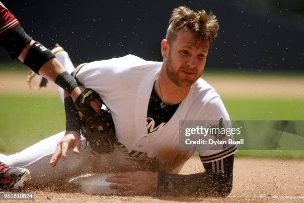 Jett Bandy of the Milwaukee Brewers slides safely into third base past Deven Marrero of the Arizona Diamondbacks in the fourth inning at Miller Park...