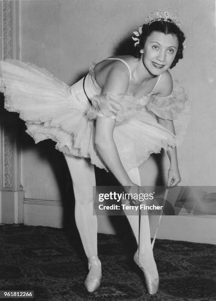 Russian ballet dancer Raisa Struchkova ties up her ballet shoes during a rehearsal at the Palace Hotel in Lancaster Gate, London, for a performance...