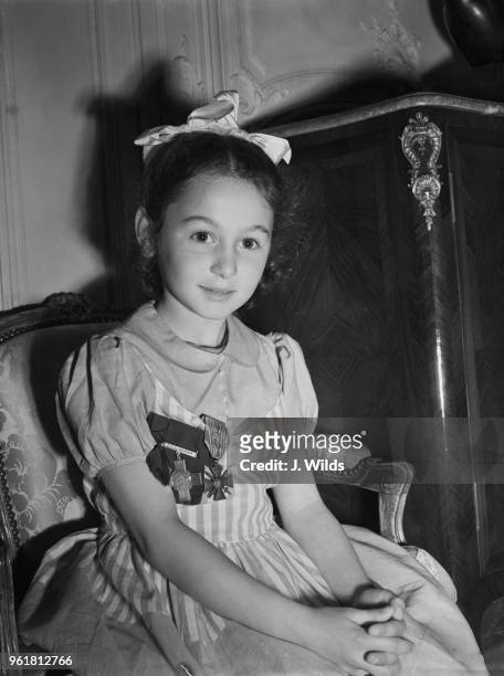 Six-year-old Tania Szabo at the French Embassy in London wearing the George Cross, and the Croix de Guerre which has just been awarded posthumously...