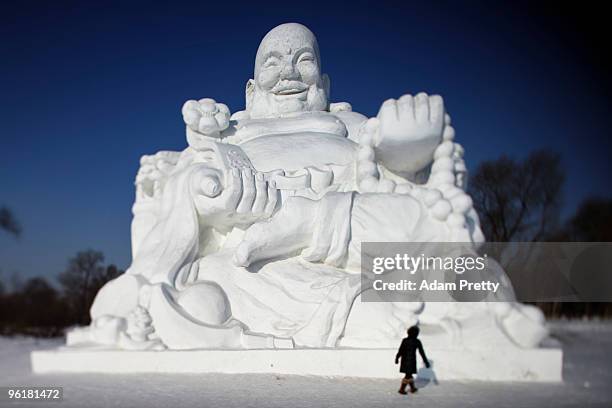 Person inspects a huge Buddha during the 26th Harbin International Ice and Snow Sculpture Festival on January 24, 2010 in Harbin, China. The...