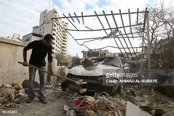 An Iraqi man removes debris a day after a bomb blast near the Hamra Hotel in Jadriyah, south of Baghdad, on January 26, 2010. Three huge and...