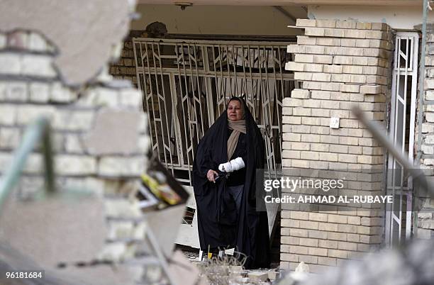 An Iraqi woman, who was wounded in a bomb blast on January 25, inspects damages at the site of the blast near the Hamra Hotel in Jadriyah, south of...