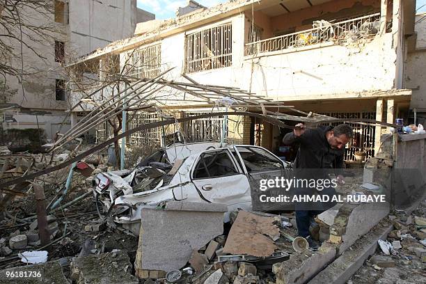 An Iraqi man inspects damages a day after a bomb blast near the Hamra Hotel in Jadriyah, south of Baghdad, on January 26, 2010. Three huge and...