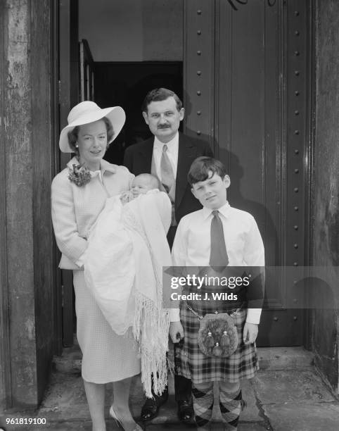 David Macpherson, 2nd Baron Strathcarron and Lady Strathcarron with their sons Ian David Patrick and Charles Andrew, during Ian's christening at...