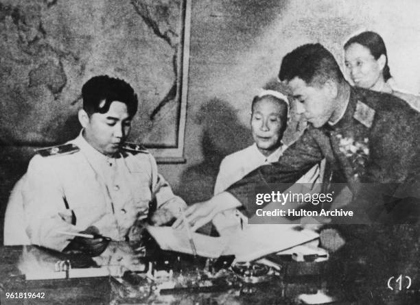 North Korean leader Kim Il-sung signs the Korean Armistice Agreement at Pyongyang, North Korea, assisted by General Nam Il , 1953.