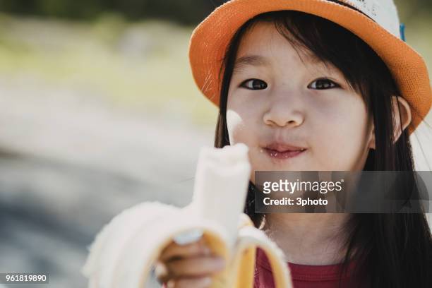 cute 3-4 years girl eating banana - city life in almaty stockfoto's en -beelden
