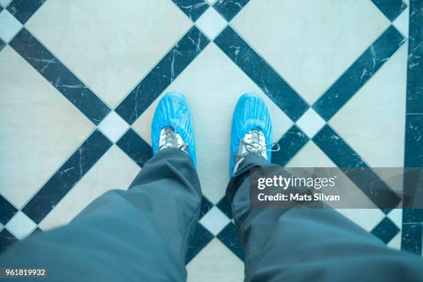 man with shoe protector - shoe covers stock pictures, royalty-free photos & images