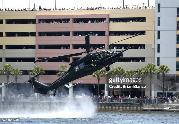 Spectators look on as a Black Hawk UH-60 helicopter flies by Tampa General Hospital after inserting special operators into Tampa Bay during an...